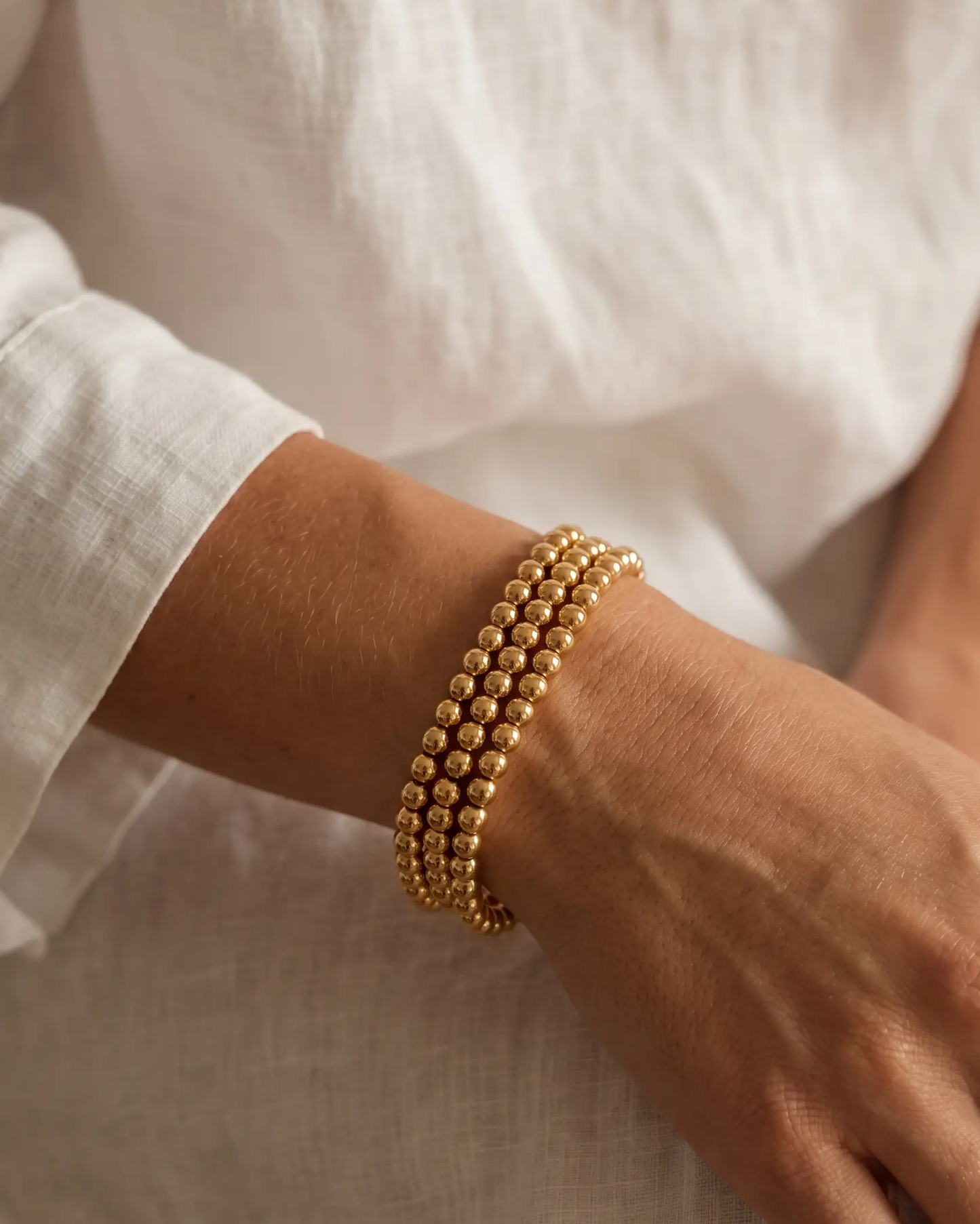 studio-ai bracelet-trio-gold-bead-bracelet-stack_studio2_a1+solo.png