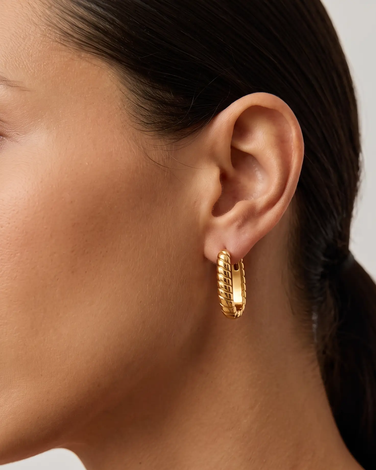 studio-ai earrings-vega-twist-huggies_lifestyle1_a1+solo.png
